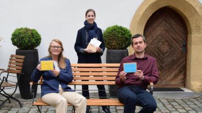 Bild: Stadtmuseum Amberg/Dagmar Lehner/exb
Sigrid Merkl, Julia Riss und Michael Herzog mit den Sprichwort-Karten im Hof des Stadtmuseums Amberg.