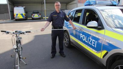 Bild: kro
Will man innerorts eine Fahrradfahrer überholen, muss ein seitlicher Abstand von 1,50 Meter gewahrt werden. Polizeihauptkommissar Manfred Liebl zeigt anhand eines Meterstabs den einzuhaltenden Abstand.