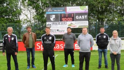 Bild: ow
Die neue Anzeigetafel (im Hintergrund) zeigt den aktuellen Spielstand und die Spieldauer an. Den Rahmen bilden die Namen der Sponsoren, die sie finanziert haben. Darüber freut sich Bürgermeister Wolfgang Haberberger mit den Sponsoren.