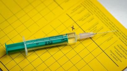 Bild: Friso Gentsch
Eine Spritze liegt auf einem Impfpass. Foto: Friso Gentsch/dpa/Illustration