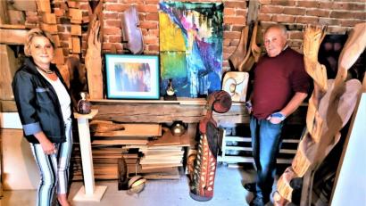 Bild: lg
Maria Schießl und Alfred Tragl präsentieren im Atelier des Muschenrieder Holzbildhauers in einer Zusammenschau eigene Lieblingsobjekte. Dazu zählen die Acrylbilder in der Mitte und die janusköpfige Figur rechts.