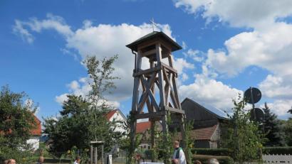 Bild: jzk
„Die Glocke soll festlich läuten bei frohen Anlässen, aber auch tröstlich, wenn uns ein lieber Mitmensch durch den Tod vorausgeht“, sagte Stadtpfarrer Thomas Kraus (stehend) bei der Segnung des Glockenstuhls in Höflas.