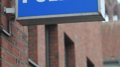 Symbolbild: Stefan Sauer/dpa
Ein Schild mit dem Schriftzug "Polizei" hängt an einer Polizeiwache.