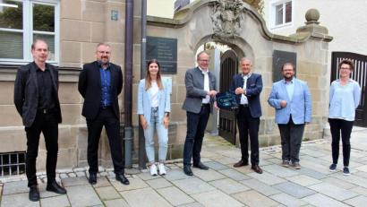 Bild: stg
Die Tafel mit "Wirtschaftsregion Landkreis Tirschenreuth" weist auf die künftigen Außensprechtage im Kemnather Rathaus hin: (von links) Bildungsmanager Hilmar Fütterer, die beiden Wirtschaftsförderer Volker Höcht und Isabel Sommerer, Bürgermeister Roman Schäffler, Landrat Roland Grillmeier, Bürgermeister Hans Walter sowie Kerstin Hörl vom Kemnather Stadtmarketing.