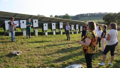 Bild: bjp
Aufmerksam hören die Gemeinderatsmitglieder zu, als Ingenieur Norbert Schwab (links, neben Anlagenbetreiber Josef Ackermann) die Technik der jüngsten Trabitzer Freiflächen-Solaranlage erklärt.