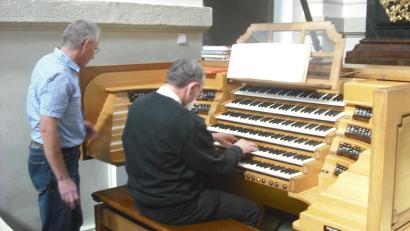 Bild: jzk
Franz Ballon (stehend) nahm sich viel Zeit, um den Hobbyorganisten Helmut Mohr die vielen Klangmöglichkeiten der Basilika Orgel aufzuzeigen und ihm die Spielweise auf den sechs Manualen zu erklären.