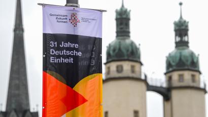 Bild: Hendrik Schmidt
Ein Banner mit der Aufschrift "31 Jahre Deutsche Einheit" hängt vor den Türmen der Marktkirche "Unser Lieben Frauen" in Halle (Saale). In der Stadt finden in diesem Jahr die zentralen Feierlichkeiten zum Tag der Deutschen Einheit statt.