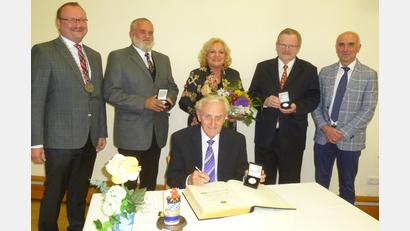 Bild: bk
Der Freihunger Bürgermeister Uwe König verleiht Bürgermedaillen in Silber an Harald Häusler, Irmgard Macke und Hermann Lühr (hinten, von links). Helmut Klier (sitzend) erhält die Goldene und trägt sich ins Goldene Buch der Marktgemeinde ein. Ihnen allen gratuliert Zweiter Bürgermeister Klaus Siegert (rechts).