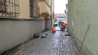 Bild: dob
In der Rathausgasse wird von den städtischen Bauhofarbeitern mittig ein Streifen Granitplatten verlegt, damit Rollstuhl- und Rollatorfahrer ungehindert zur im nächsten Jahr geplanten Toilettenanlage fahren können. Aus dem westlichen Stadtgebiet kann dadurch jetzt problemlos zum Rathaus gefahren werden.