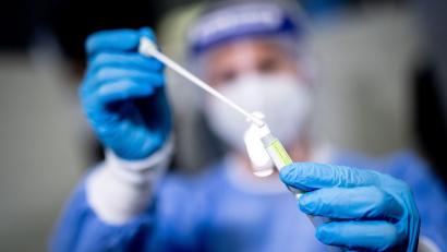 Symbolbild: Matthias Balk/dpa
Eine Mitarbeiterin hält in einem Covid-19-Testcenter die Probe von einem Rachenabstrich in den Händen.