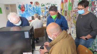 Bild: jzk
Arno Preißinger (sitzend) gab sich viel Mühe, um das defekte Gerät fachgerecht zu reparieren.