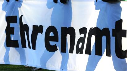 Bild: Patrick Seeger/dpa
Jugendliche halten ein Banner mit der Aufschrift «Ehrenamt» in den Händen.