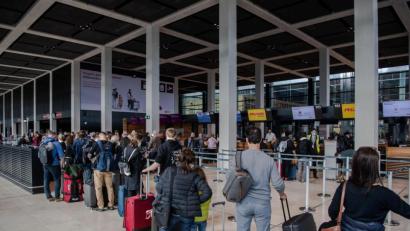 Bild: Paul Zinken/dpa
Reisende stehen am Flughafen BER vor einem Check-in-Schalter. Corona-Regeln beschränken weiterhin das freie Reisen. Foto: Paul Zinken/dpa