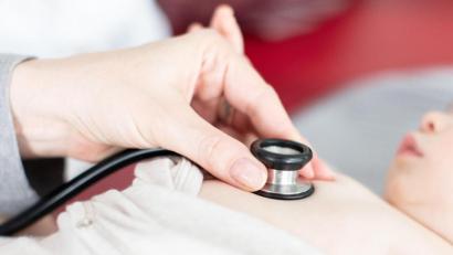 Symbolbild: Friso Gentsch/dpa
Ein Kind wird von einem Arzt mit einem Stethoskop abgehört.