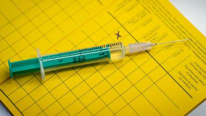 Bild: Friso Gentsch
Eine Spritze liegt auf einem Impfpass. Foto: Friso Gentsch/dpa/Illustration