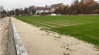 Bild: Wilhelm Amann
Der neue Sportplatz (Bild) für die Grund- und Mittelschule (Hintergrund) ist bereits angelegt. Für die künftige Bewässerung lässt die Stadt einen Brunnen bohren.