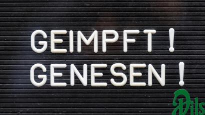 Bild: Robert Michael
„Geimpft! Genesen!“ steht auf einem Schild an einer Bar.