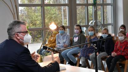 Bild: Stephan Huber
Zieht die Fünftklässler in seinen Bann: Bürgermeister Michael Göth liest in der Aula am HCA-Gymnasium aus dem Roman "Drachenreiter" von Cornelia Funke vor.