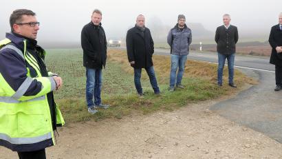 Bild: Wolfgang Steinbacher
Noch liegt sie im dichten Nebel, doch für die Staatsstraße 2399 zwischen Raigering und Lintach soll schon bald die Sonne aufgehen. Dafür sorgen (von links): Baudirektor Stefan Noll (Staatliches Bauamt), Alwin Märkl (Bürgermeister Freudenberg), Helmut Seebauer (Bauunternehmer), Michael Reng (Bauleitung), Landtagsabgeordneter Harald Schwartz und Landrat Richard Reisinger.