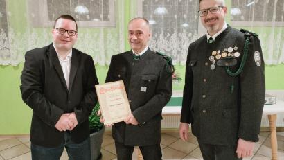 Bild: adj
Schützenmeister Manuel Stich (links) und Christian Behr (rechts) übergeben Ehrenschützenmeister Jürgen Merkl (Mitte) die Urkunde.