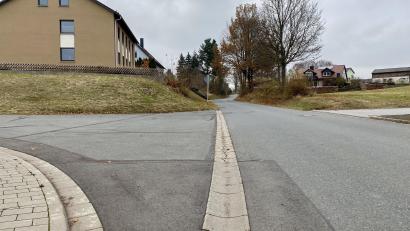 Bild: Eichl
Gleich hinter der Wertstoffinsel schräg gegenüber dem Friedhof endet der Gehweg, er beginnt erst wieder nach den drei Häusern auf der linken Seite. Schüler müssen auf dem Weg zur Bushaltestelle an der 2166 auf der Straße gehen.