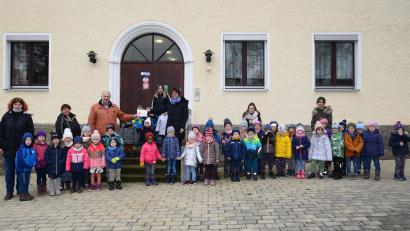 Bild: bey
Kindergartenleiterin Beate Schuch (auf der Haustreppe, rechts) übergibt dem Vorsitzenden der Kinderkrebshilfe Oberpfalz Herbert Putzer den am Martinstag in der Andacht gesammelten Betrag von 230 Euro.