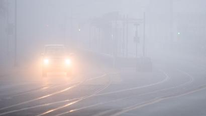 Symbolbild: Julian Stratenschulte/dpa
Autos fahren bei dichtem Nebel über eine Straße.