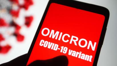 Symbolbild: Pavlo Gonchar/dpa
Auf dem Bildschirm eines Smartphones ist der Text «Omicron COVID-19-variant» zu lesen. Die Omikron-Variante war zuerst im südlichen Afrika nachgewiesen worden.