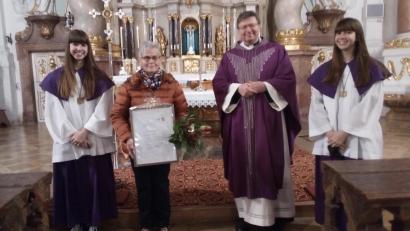 Bild: Luitpold Dietl
Pater Markus Flasinski überreichte Hildegard Wolf eine Dankurkunde zum Ende ihres Dienstes als Kommunionhelferin. Mit auf dem Bild die Enkelinnen von Hildegard Wolf, die Ministrantinnen Antonia (links) und Sophia Müller.