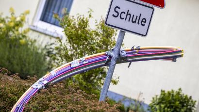 Bild: Jens Büttner/dpa
Leerrohre mit unterschiedlichen Durchmessern und Farben für das spätere Einblasen von Glasfaserkabeln hängen an einer Baustelle für den Breitband-Internetausbau für eine Schule.