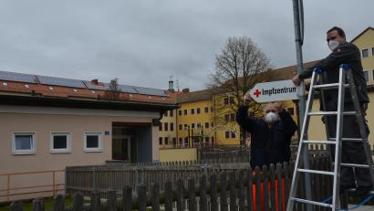 Bild: dob
BRK-Helfer Heinrich Rewitzer (links) und Grundschulhausmeister Thomas Beierl bringen am Montag das Schild "Impfzentrum" vor der Eglsee-Turnhalle in Vohenstrauß an. Hier wird nun wie schon im Frühjahr geimpft: Bis 30. November dienstags und mittwochs, danach montags bis freitags.