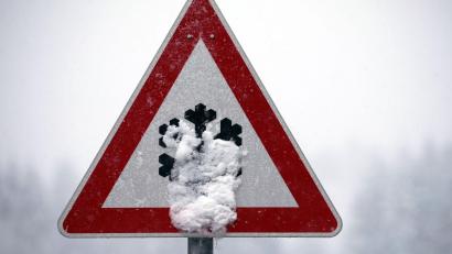 Symbolbild: Karl-Josef Hildenbrand/dpa
Ein Verkehrsschild, auf dem vor Schnee- und Eisglätte gewarnt wird, ist mit Schnee bedeckt.