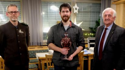 Bild: le
Schützenmeister Siegfried Kellner (links) und Fred Lehner (rechts) überreichen den Pokal an Dominik Kraus.