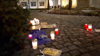 Bild: pz
Die kleine Gedenkstätte zwischen Brunnen und Christbaum am Basilikaplatz am Sonntagabend.