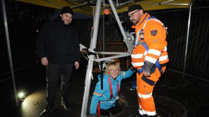 Bild: bey
Zweite Bürgermeisterin Sigrid Ziegler wagt den Abstieg in den Untergrund, um sich ein Bild vom Umfang der Sanierungsarbeiten am Oberwildenauer Regenrückhaltebecken zu machen. Bürgermeister Sebastian Hartl (links) fungiert als Helfer auf der Baustelle.