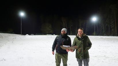 Bild: bsc
Die einst schlechten Lichtverhältnisse auf dem Trainingsplatz des TSV Friedenfels sind seit Freitag endgültig Vergangenheit. Zusammen mit den Monteuren einer Spezialfirma nahmen der Vorsitzende des Turn- und Sportvereins Friedenfels, Johannes Härtl (links), und Fußball-Abteilungsleiter Christian Härtl (rechts) die neue Anlage (im Hintergrund) in Betrieb.