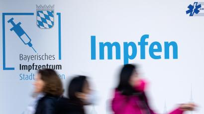 Symbolbild: Sven Hoppe
Passanten laufen an einem Impfzentrum in der Münchener Innenstadt vorbei.