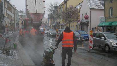 Bild: hmr
Entlang der Bundesstraße 299 durch Waldsassen ist am Mittwoch die Asphalt-Feinschicht neben den neuen Pflasterrinnen aufgetragen worden.