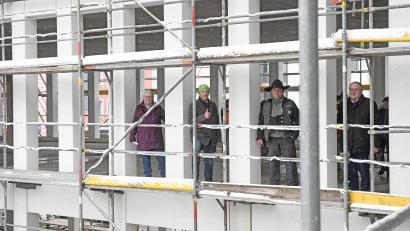 Bild: Gabi Schönberger
In der klar gegliederten Fertigbetonfassade der künftigen AOK Geschäftsstelle stehen Gaby Hübner (von links), Jürgen Spickenreuther, Polier Markus Günther und Lothar Höher beim dezemberlichen Richtfest fast wie in einem großen Adventskalender.
