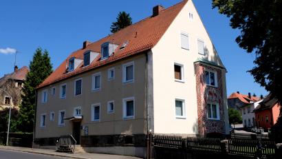 Bild: le
Noch ist das große Wohnbauprojekt im Ortsteil Plankenhammer, der Neubau von zehn barrierefreien Mietwohnungen, nicht fertig, planen Vorstandsvorsitzende Marika Mauerer, Vorstand und Aufsichtsrat des Bauvereins, die anstehende Sanierung von Mietwohnungen im Anwesen Flossenbürger Straße 24 (Bild). Dort hat auch die Geschäftsstelle der Genossenschaft ihren Sitz. Geplant sind barrierefreie Mietwohnungen im Erdgeschoss des Hauses mit einem neuen Seiteneingang, wo auch künftig die Geschäftsstelle Einzug halten soll. Durch das Freiwerden von vier Mietwohnungen wird dieses Bauprojekt erleichtert.