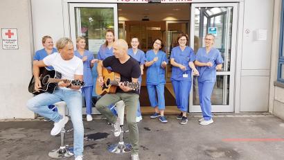 Bild: Marion Hausmann /exb 
Das Austropop-Duo „Zwoa Achter`l – bitte!“ sorgte bei den Dreharbeiten zum Geburtstagssong „Dei offene Tür“ sowohl im Herzkatheterlabor als auch vor der Zentralen Notaufnahme des Krankenhauses St. Barbara Schwandorf spontan für gute Stimmung.