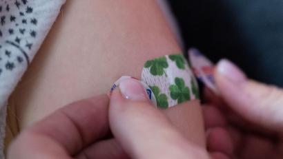 Symbolbild: Bernd Weißbrod/dpa
Eine Impfärztin klebt ein Pflaster auf den Oberarm eines Kindes.