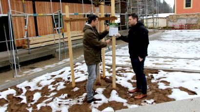 Bild: ds
An der Dorflinde in Kirchenreinbach weist ein Schild auf das 40-jährige Bestehen des Amtes für ländliche Entwicklung hin. Steffen Hauser (rechts) und Bürgermeister Roman Berr bringen es am Bockgerüst des frisch gepflanzten Baumes an.