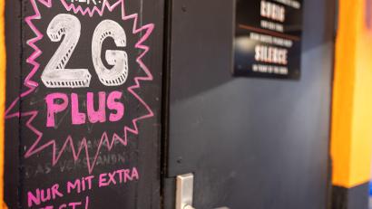 Symbolbild: Daniel Karmann/dpa
Hinweis auf 2G plus bei einer Bar in der Nürnberger Innenstadt.