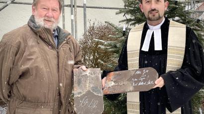Bild: wku
Vertrauensmann Ulrich Gerlach (links) und Pfarrer Stefan Fischer mit den Kirchendachziegeln, die Landesbischof Bedford Strohm und Ministerpräsident Markus Söder signiert haben.