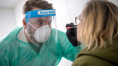 Bild: Sina Schuldt
Der Mitarbeiter eines Corona-Testzentrums nimmt einen Abstrich für einen PCR-Test vor.