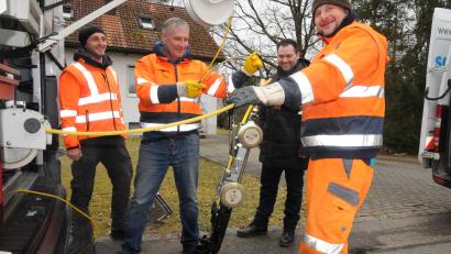 Bild: bey
Bauhofleiter Stephan Glossner (links) und Bürgermeister Sebastian Hartl (2. von rechts) beobachten das Herablassen der Kamera in den Kanal. Die Kamera muss oftmals den Verhältnissen im Untergrund angepasst werden.