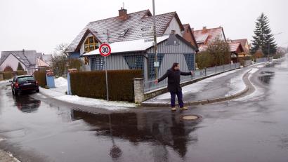 Bild: bkr
Von links kommt das Problem bei Regengüssen. An der Einmündung, dort wo vor dem Kanaldeckel Bürgermeister Thomas Kaufmann steht, treffen die Abwässer aus dem westlichen Bereich der Hofloher Straße und vom Feuerwehrgerätehaus zusammen. In Richtung Bauhof müssen sie weiter. Für das Gros heißt es scharf rechts herum.