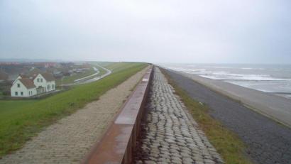 Bild: picture alliance / dpa
Ein Ort liegt an einem Deich hinter einem Strand in den Niederlanden.