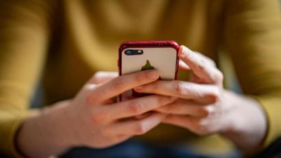 Bild: Fabian Sommer/dpa/Illustration
Eine junge Frau hält ein Smartphone in der Hand.